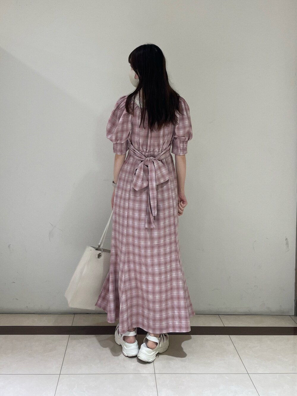 ピンク系のワンピース、ホワイト系のトートバッグを着用したレディースの夏コーディネートの2枚目の写真