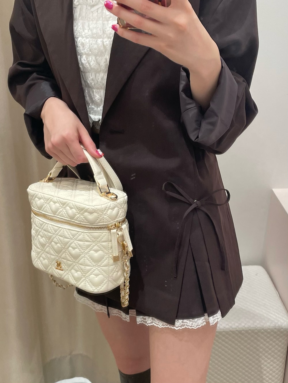 ブラウン系のテーラードジャケット、ブラウン系のスカート、ホワイト系のショルダーバッグを着用したレディースの秋コーディネートの2枚目の写真