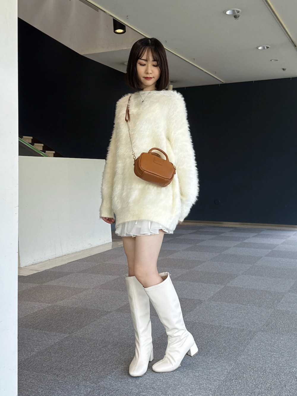 ホワイト系のワンピース/ドレス、イエロー系のボストンバッグ、ホワイト系のブーツを着用したレディースの秋コーディネートの2枚目の写真