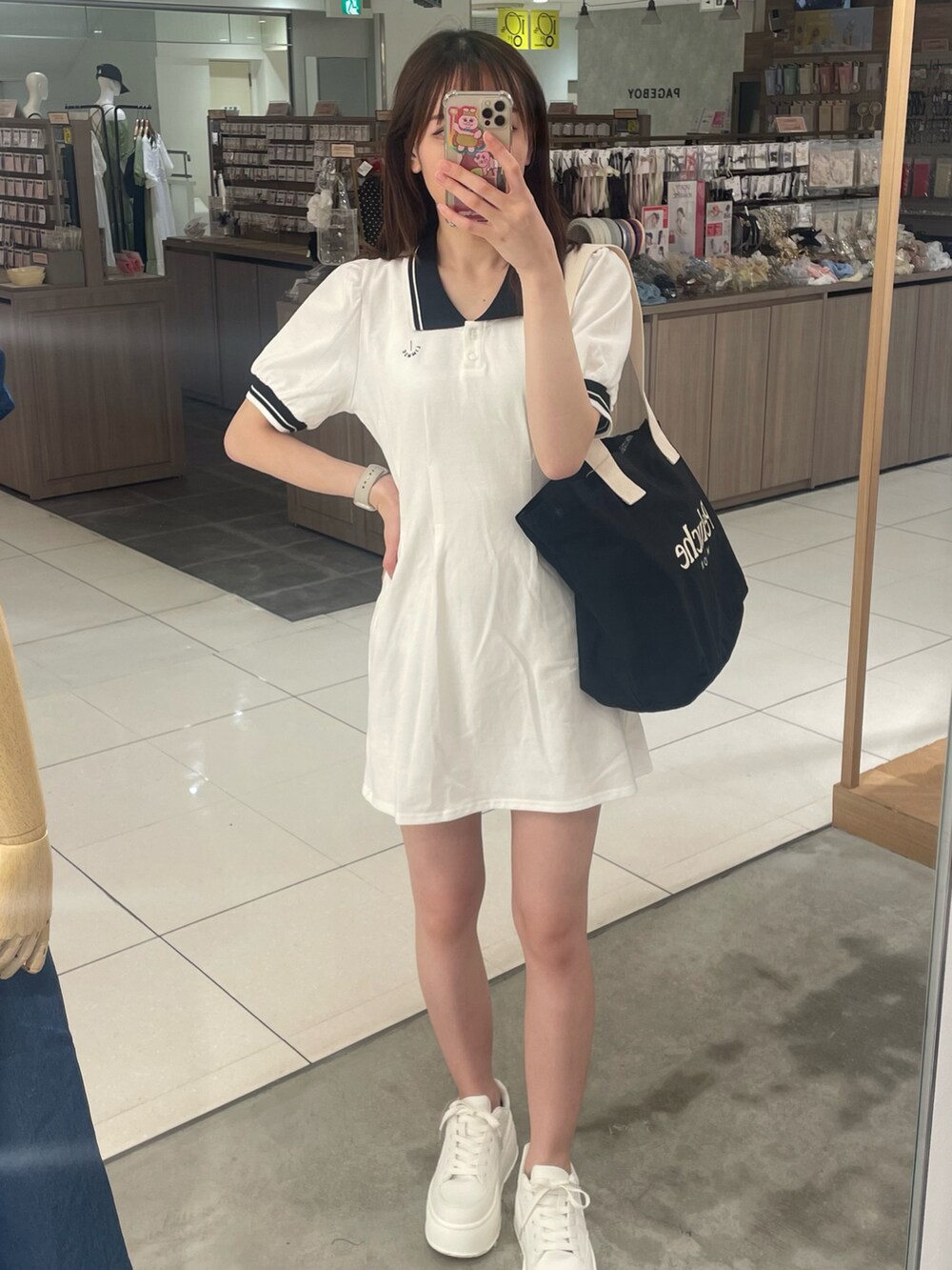 ホワイト系のワンピース、ブラック系のバッグを着用したレディースの春コーディネートの2枚目の写真