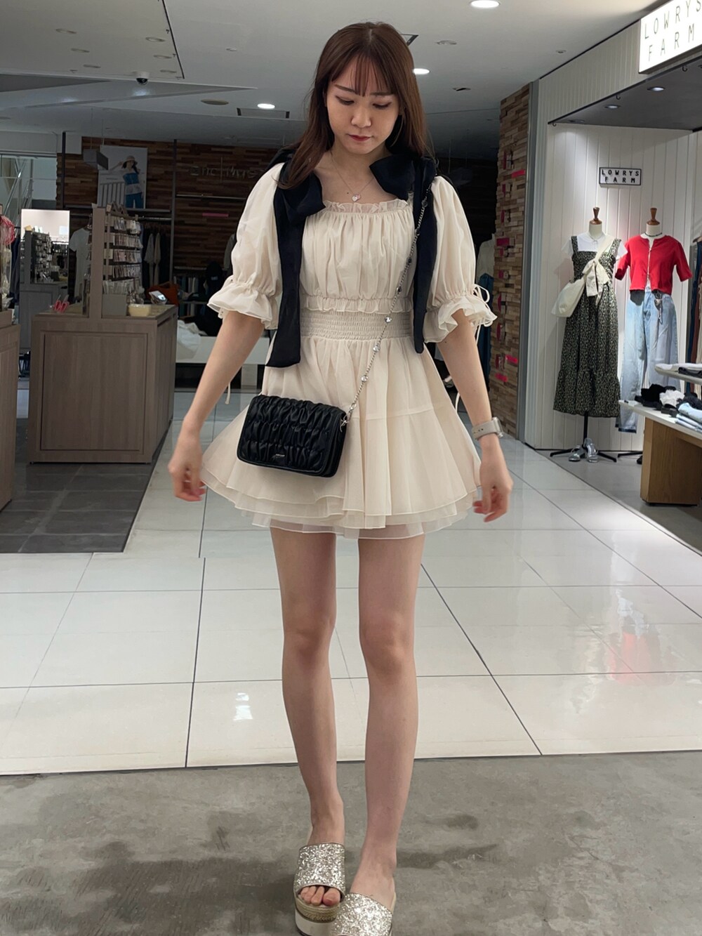 ホワイト系のシャツ/ブラウス、ブラック系のショルダーバッグ、ゴールド系のサンダルを着用したレディースの夏コーディネートの2枚目の写真