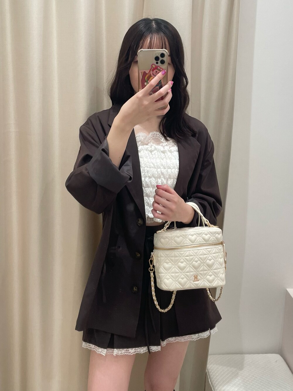 ブラウン系のテーラードジャケット、ブラウン系のスカート、ホワイト系のショルダーバッグを着用したレディースの秋コーディネートの3枚目の写真