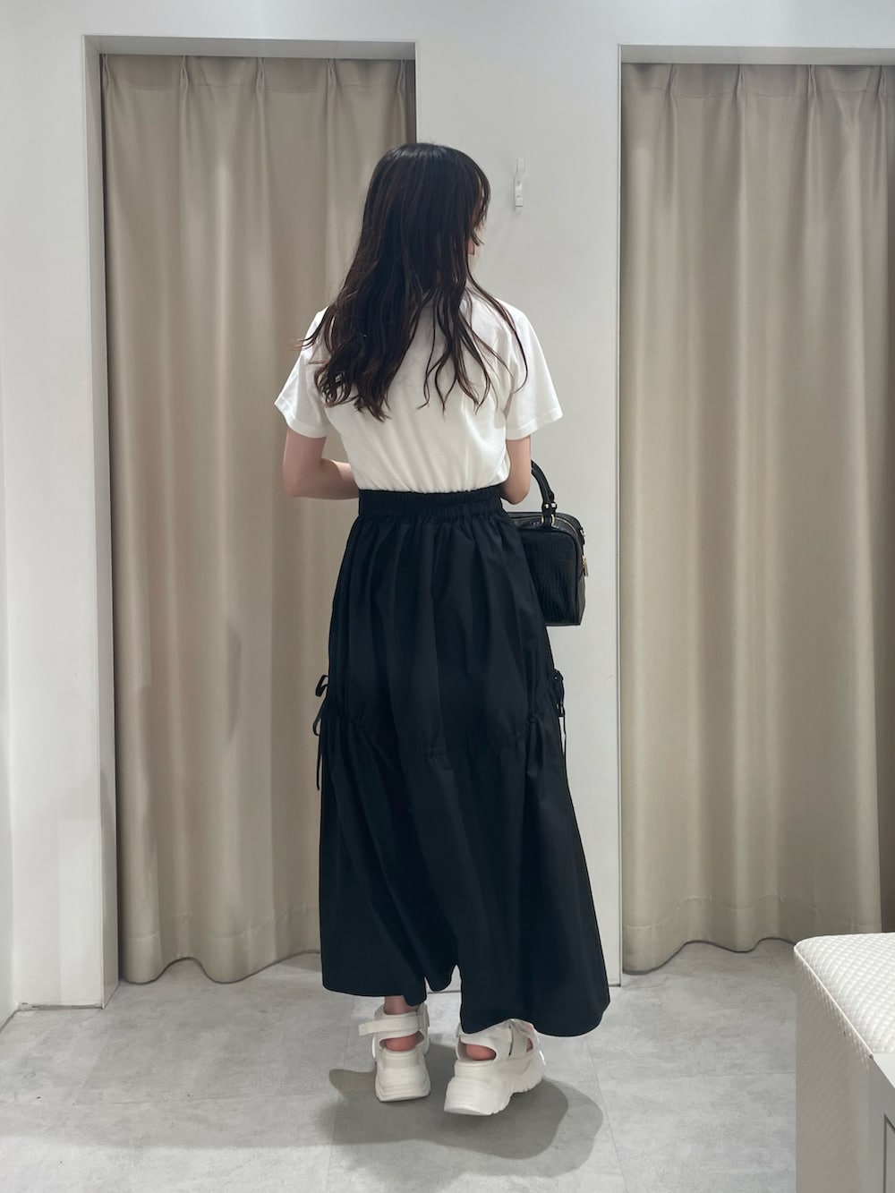 その他のTシャツ/カットソー、ブラック系のスカート、ブラック系のボストンバッグを着用したレディースの夏コーディネートの3枚目の写真