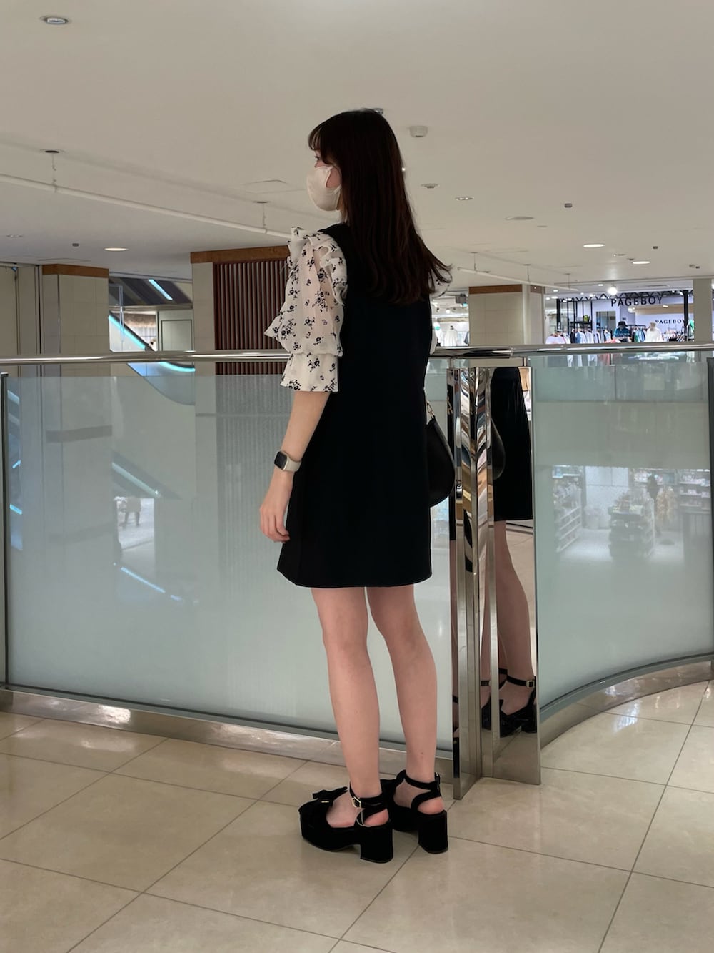 ホワイト系のワンピース、ブラック系のショルダーバッグ、ブラック系のサンダルを着用したレディースの春コーディネートの2枚目の写真