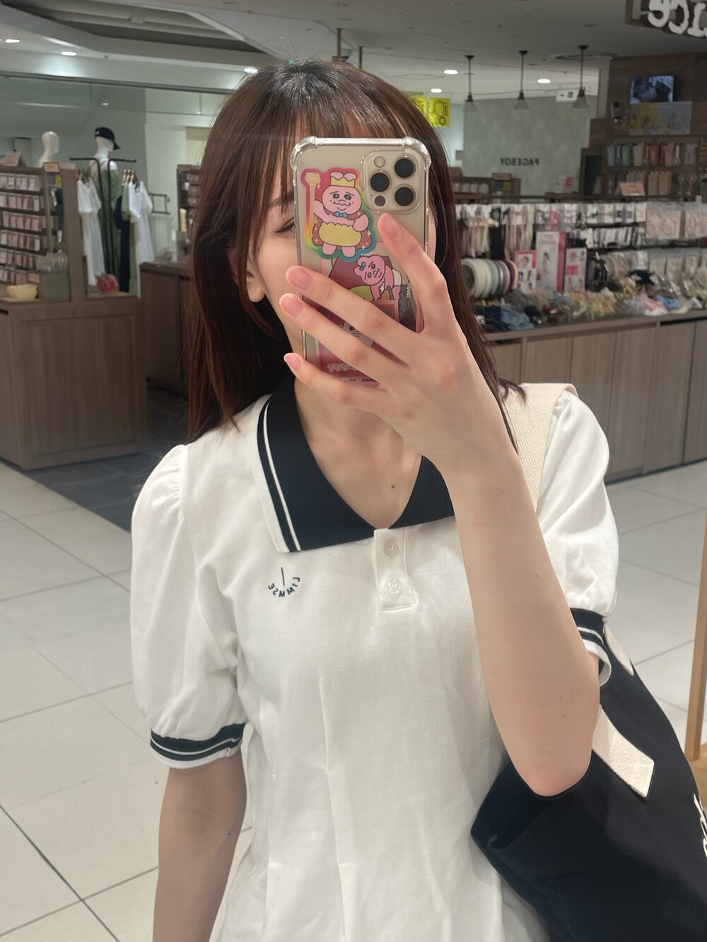 ホワイト系のワンピース、ブラック系のバッグを着用したレディースの春コーディネートの3枚目の写真