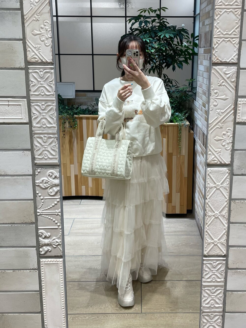 ホワイト系のスウェット、ホワイト系のスカート、ホワイト系のトートバッグを着用したレディースの秋コーディネートの2枚目の写真