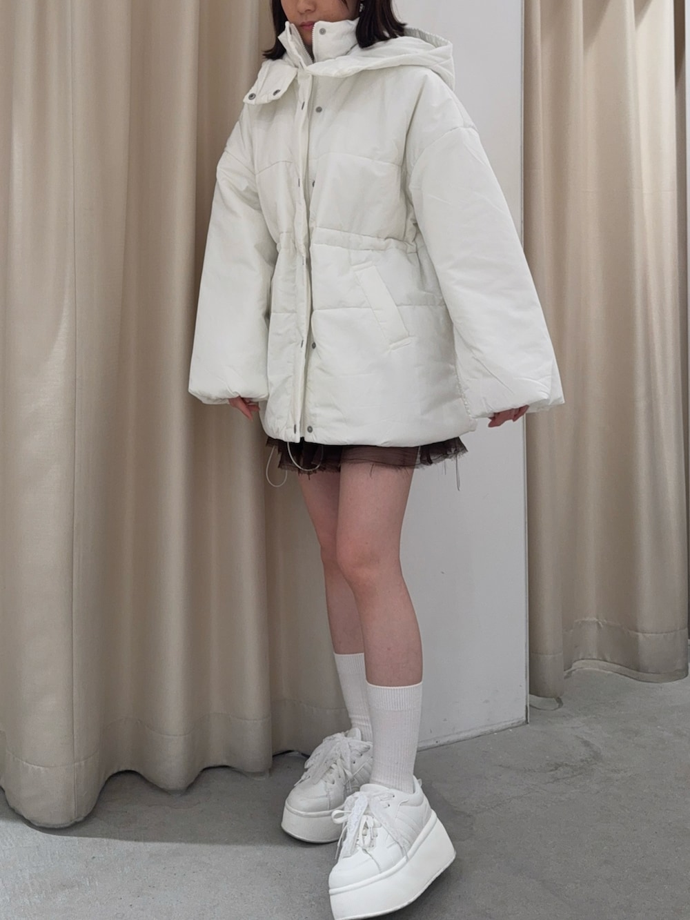 ホワイト系のダウンジャケット/コート、ホワイト系のスニーカーを着用したレディースの秋コーディネートの2枚目の写真