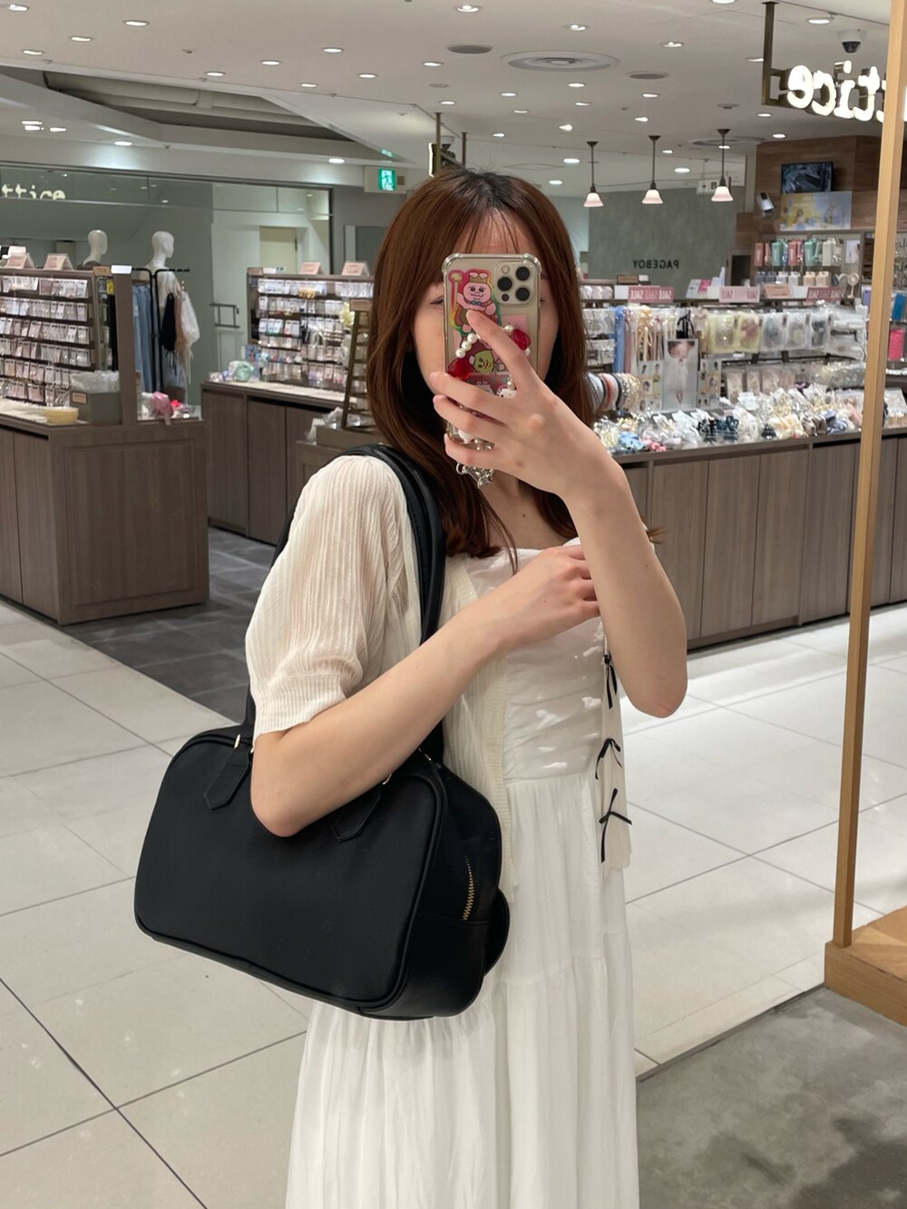 ホワイト系のカーディガン/ボレロ、ホワイト系のワンピース、ブラック系のボストンバッグを着用したレディースの夏コーディネートの2枚目の写真