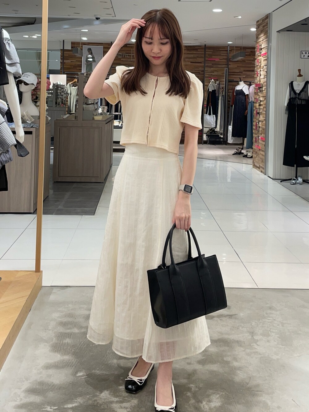 イエロー系のTシャツ/カットソー、ホワイト系のスカート、ブラック系のショルダーバッグを着用したレディースの夏コーディネートの2枚目の写真