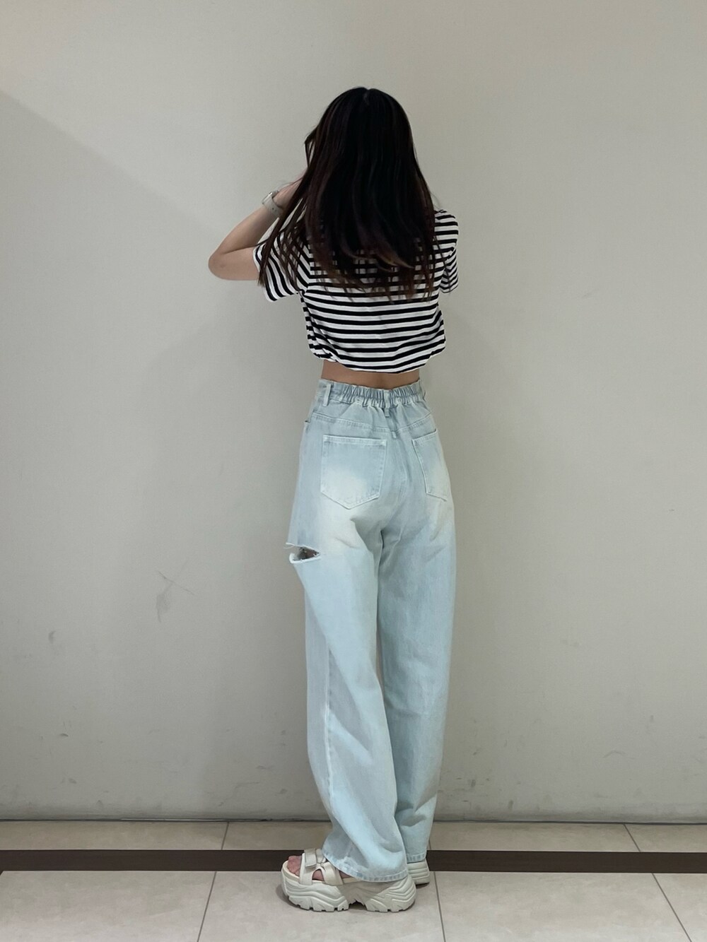 ブラック系のTシャツ/カットソー、ブルー系のデニムパンツ、ホワイト系のサンダルを着用したレディースの夏コーディネートの2枚目の写真