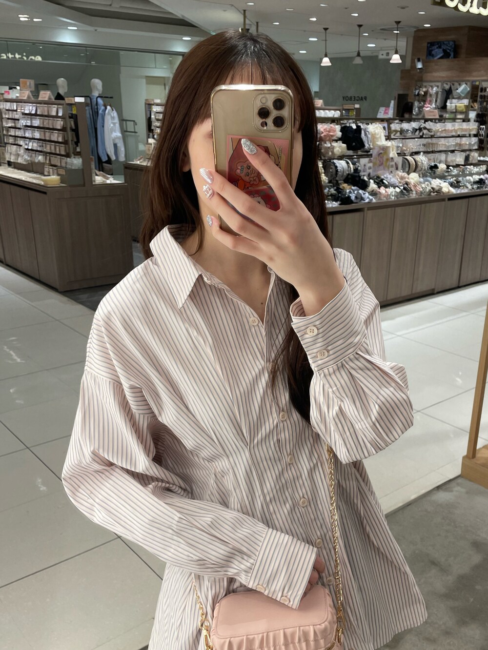 ピンク系のシャツ/ブラウス、ブルー系のデニムパンツ、ピンク系のショルダーバッグを着用したレディースの春コーディネートの2枚目の写真