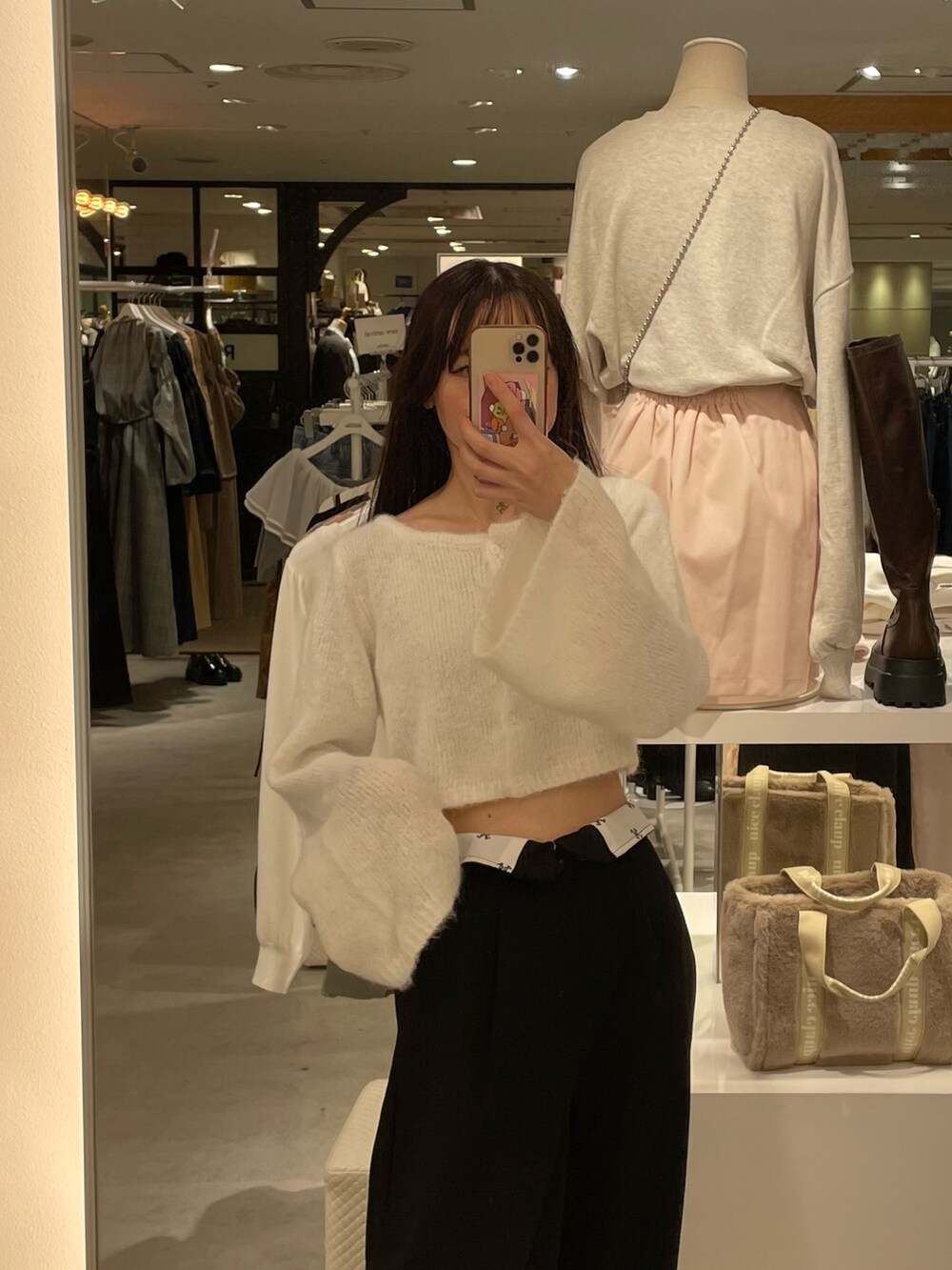 ホワイト系のニット/セーター、ブラック系のチノパンツ、ブラック系のショルダーバッグを着用したレディースの秋コーディネートの2枚目の写真