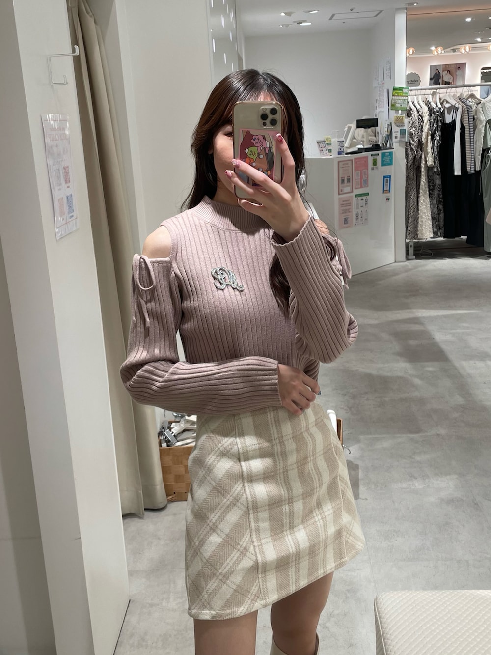 ブラウン系のニット/セーター、ホワイト系のスカート、ホワイト系のハンドバッグを着用したレディースの秋コーディネートの2枚目の写真