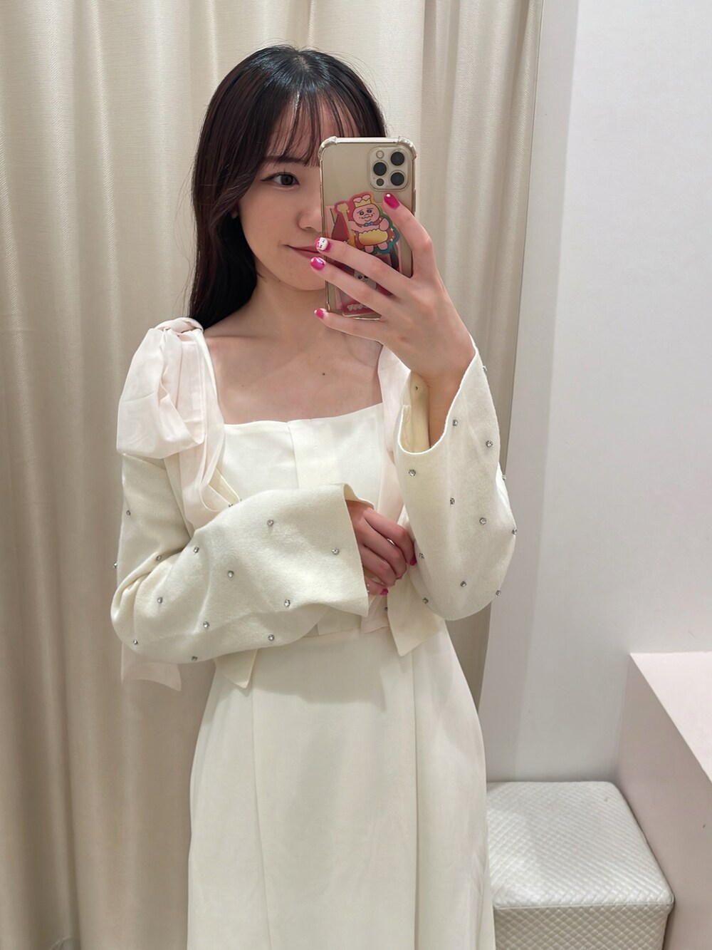 ホワイト系のカーディガン/ボレロ、ホワイト系のワンピース、ベージュ系のショルダーバッグを着用したレディースの秋コーディネートの3枚目の写真