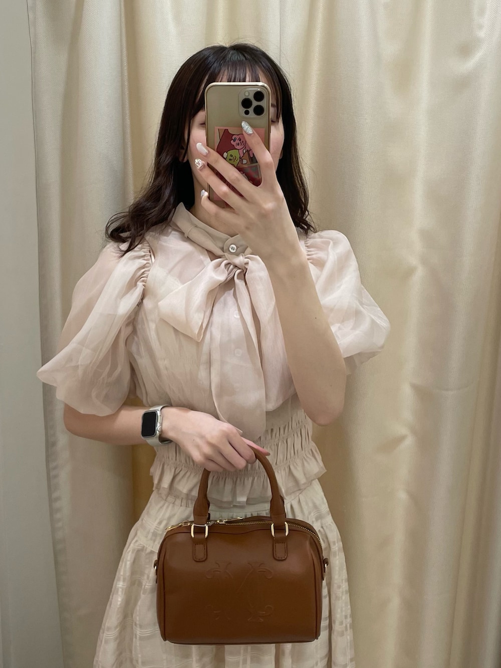 ベージュ系のシャツ/ブラウス、ホワイト系のスカート、ブラウン系のボストンバッグを着用したレディースの春コーディネートの2枚目の写真