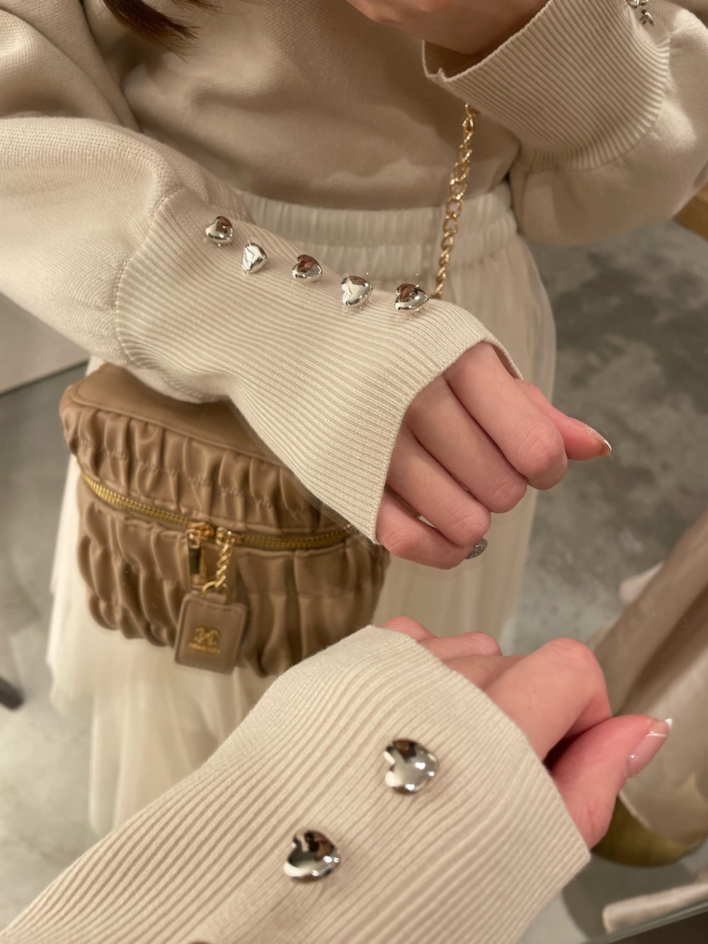 ホワイト系のニット/セーター、ホワイト系のスカート、ホワイト系のマウンテンパーカーを着用したレディースの春コーディネートの2枚目の写真