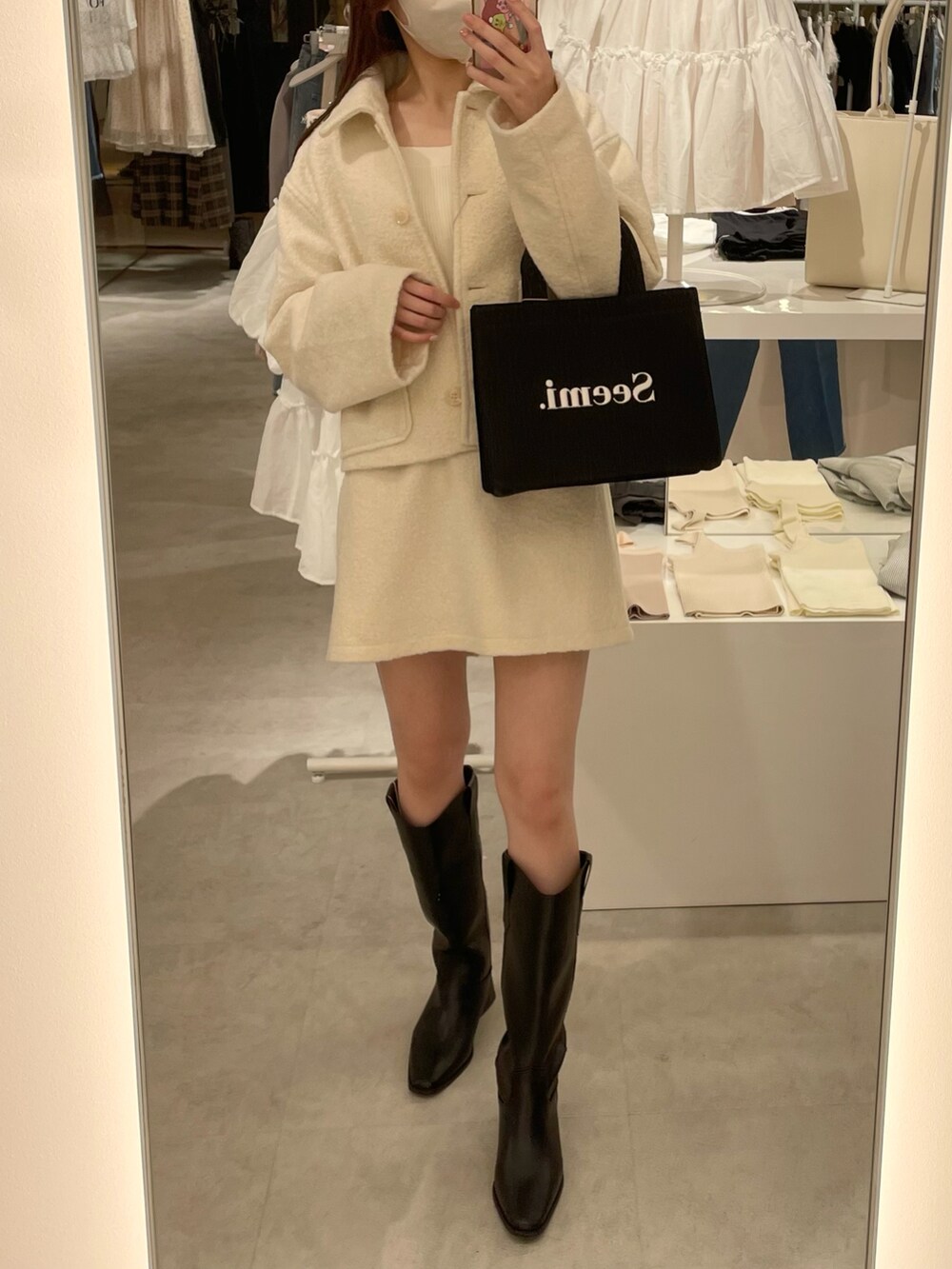 ホワイト系のその他アウター、ホワイト系のスカート、ブラック系のトートバッグを着用したレディースの夏コーディネートの3枚目の写真