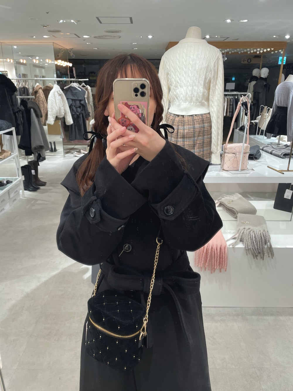 ブラック系のチェスターコート、ブラック系のショルダーバッグ、ゴールド系のバレエシューズを着用したレディースの冬コーディネートの2枚目の写真