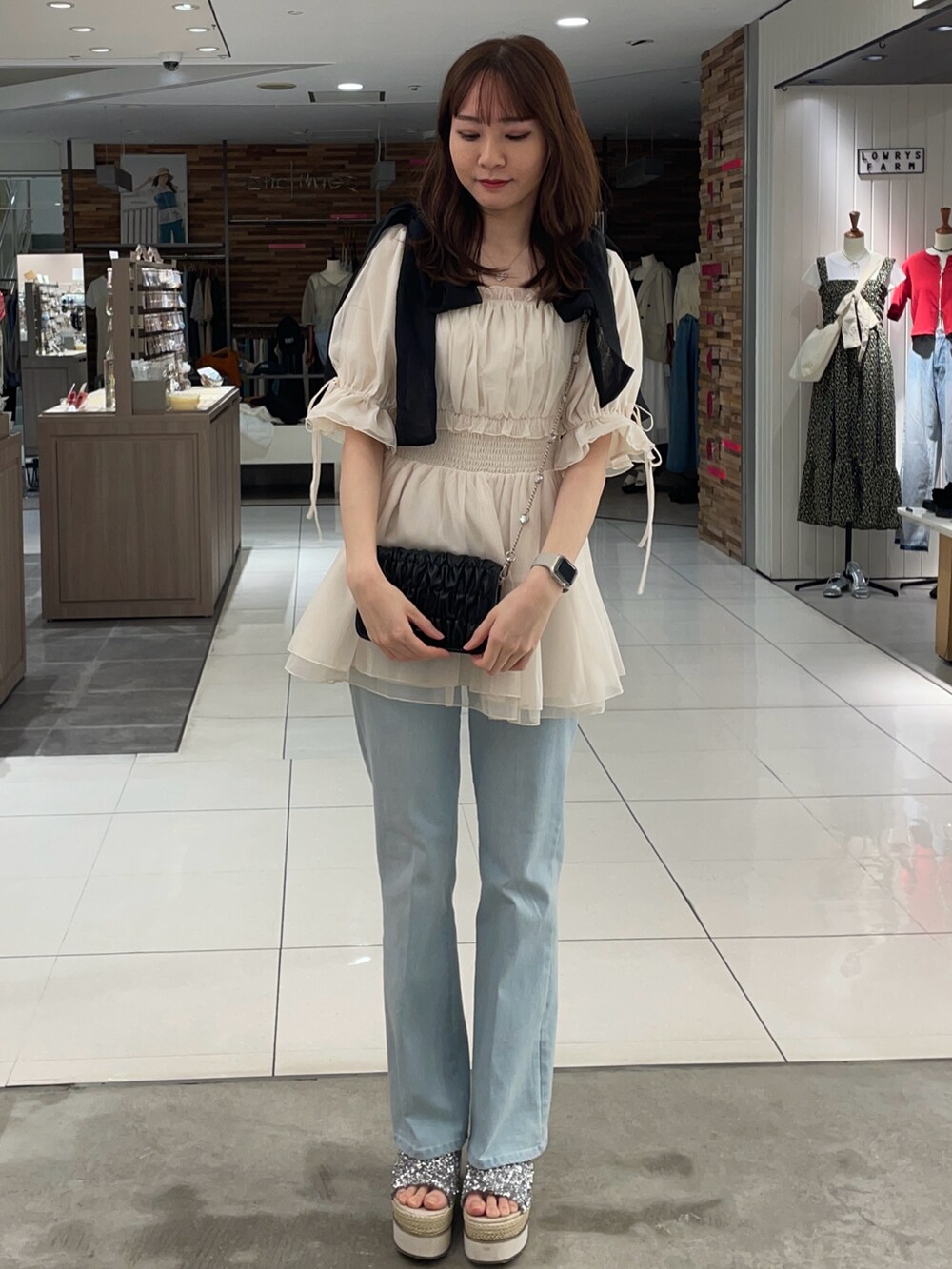 ホワイト系のシャツ/ブラウス、ブルー系のデニムパンツ、ブラック系のショルダーバッグを着用したレディースの夏コーディネートの2枚目の写真