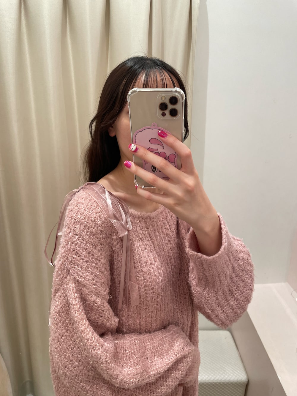 ピンク系のニット/セーター、ブラック系のショルダーバッグを着用したレディースの秋コーディネートの3枚目の写真