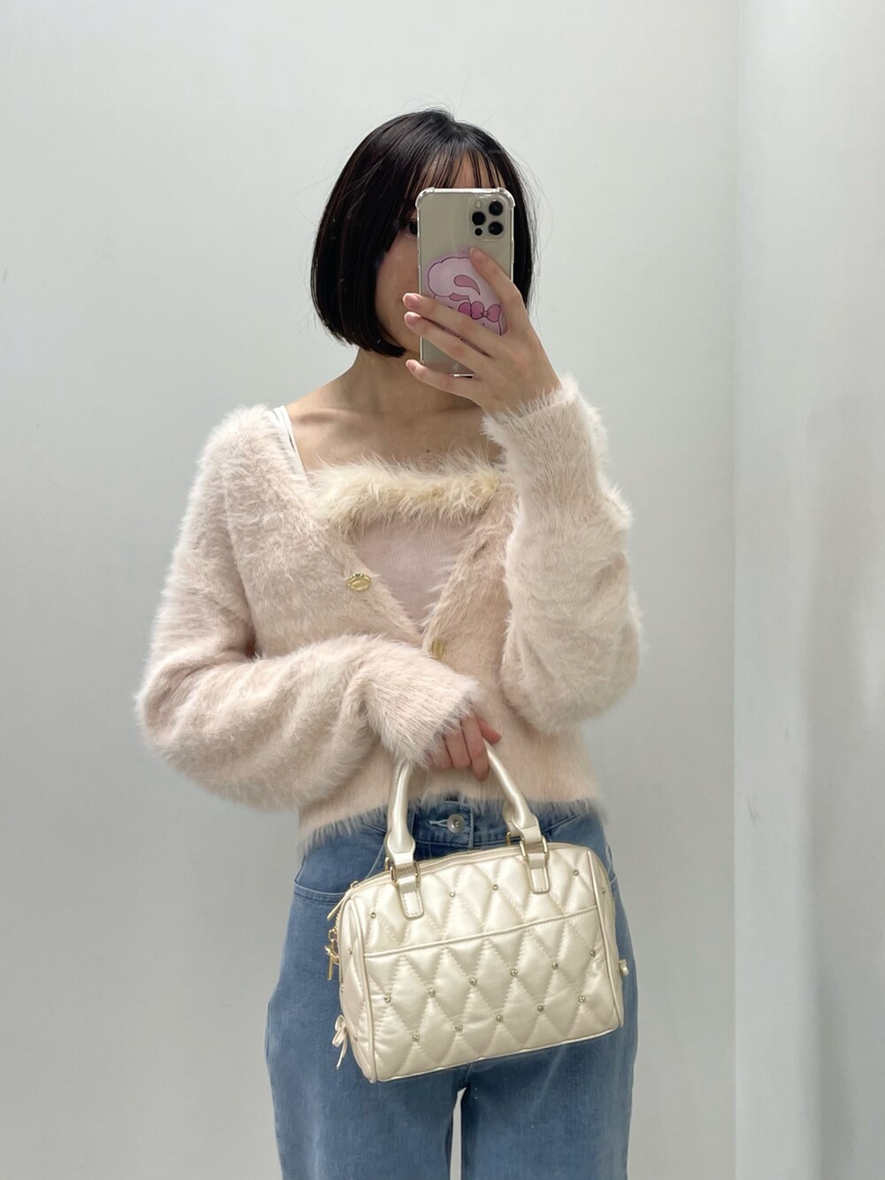 ピンク系のカーディガン/ボレロ、ホワイト系のボストンバッグ、ブルー系のデニムパンツを着用したレディースの秋コーディネートの5枚目の写真