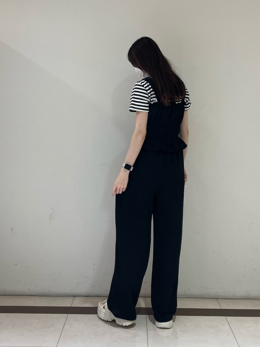 ブラック系のTシャツ/カットソー、ブラック系のパンツ、ホワイト系のサンダルを着用したレディースの夏コーディネートの2枚目の写真