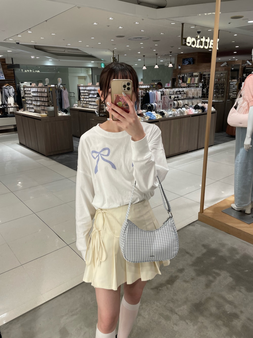 ホワイト系のTシャツ/カットソー、ホワイト系のスカート、ブルー系のショルダーバッグを着用したレディースの春コーディネートの2枚目の写真