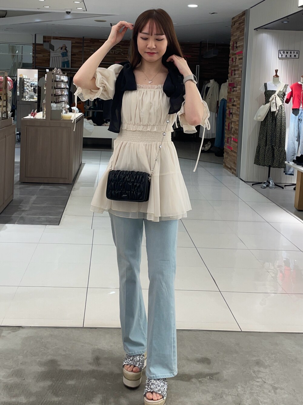 ホワイト系のシャツ/ブラウス、ブルー系のデニムパンツ、ブラック系のショルダーバッグを着用したレディースの夏コーディネートの3枚目の写真