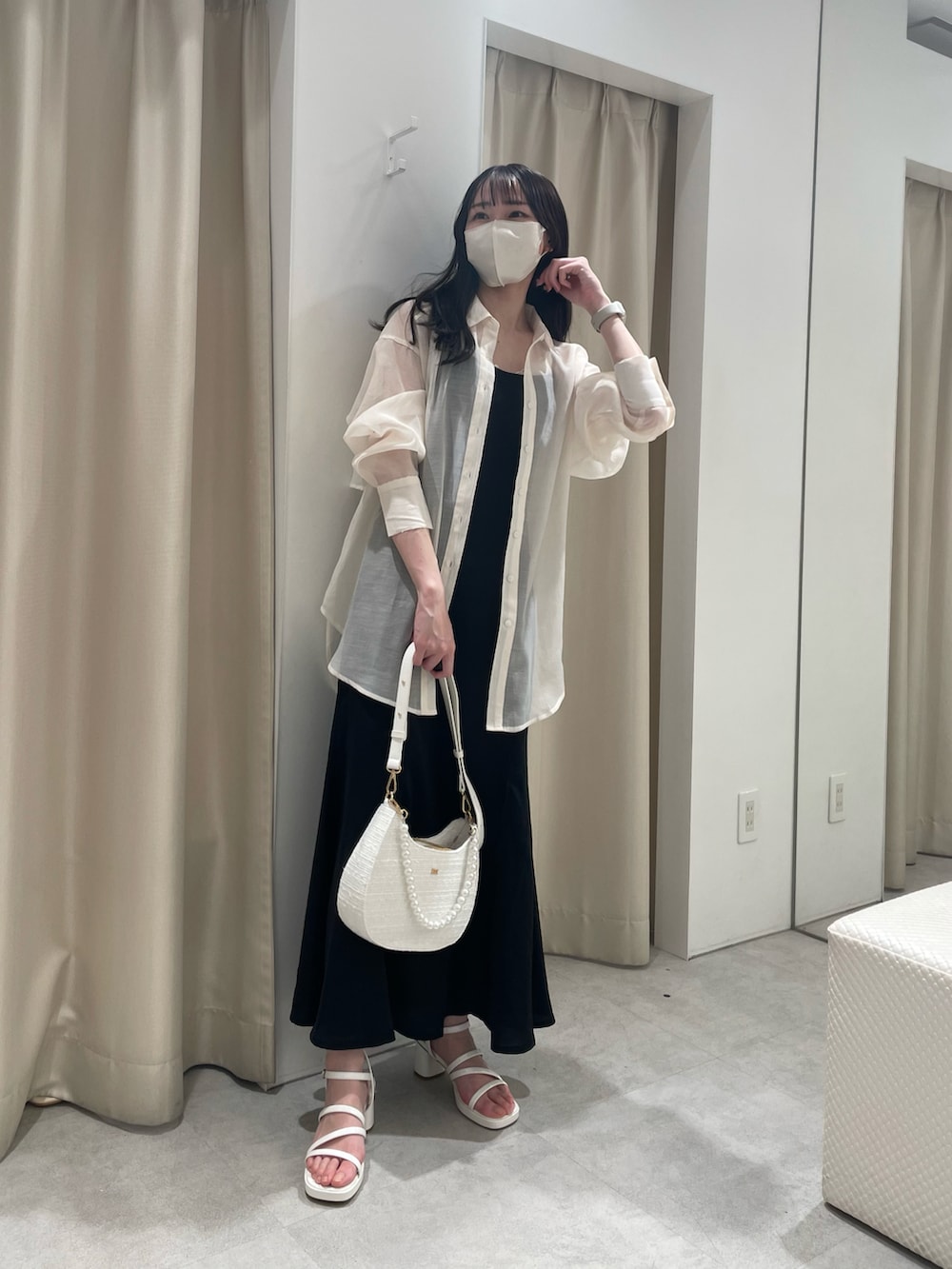 ホワイト系のシャツ/ブラウス、ブラック系のワンピース、ホワイト系のショルダーバッグを着用したレディースの春コーディネートの2枚目の写真