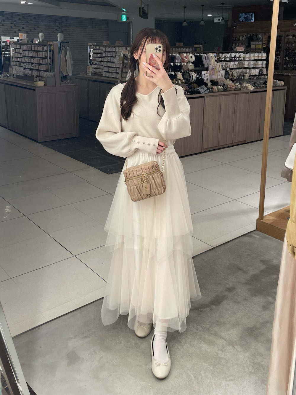 ホワイト系のニット/セーター、ホワイト系のスカート、ホワイト系のマウンテンパーカーを着用したレディースの春コーディネートの4枚目の写真