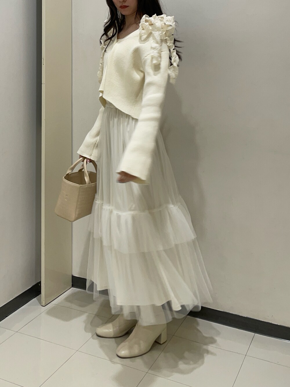 ホワイト系のカーディガン/ボレロ、ホワイト系のキャミソール、ホワイト系のスカートを着用したレディースの春コーディネートの2枚目の写真