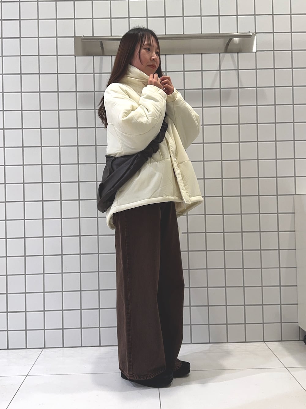 レッド系のニット/セーター、ホワイト系のダウンジャケット/コート、ブラウン系のショルダーバッグを着用したレディースの秋コーディネートの2枚目の写真