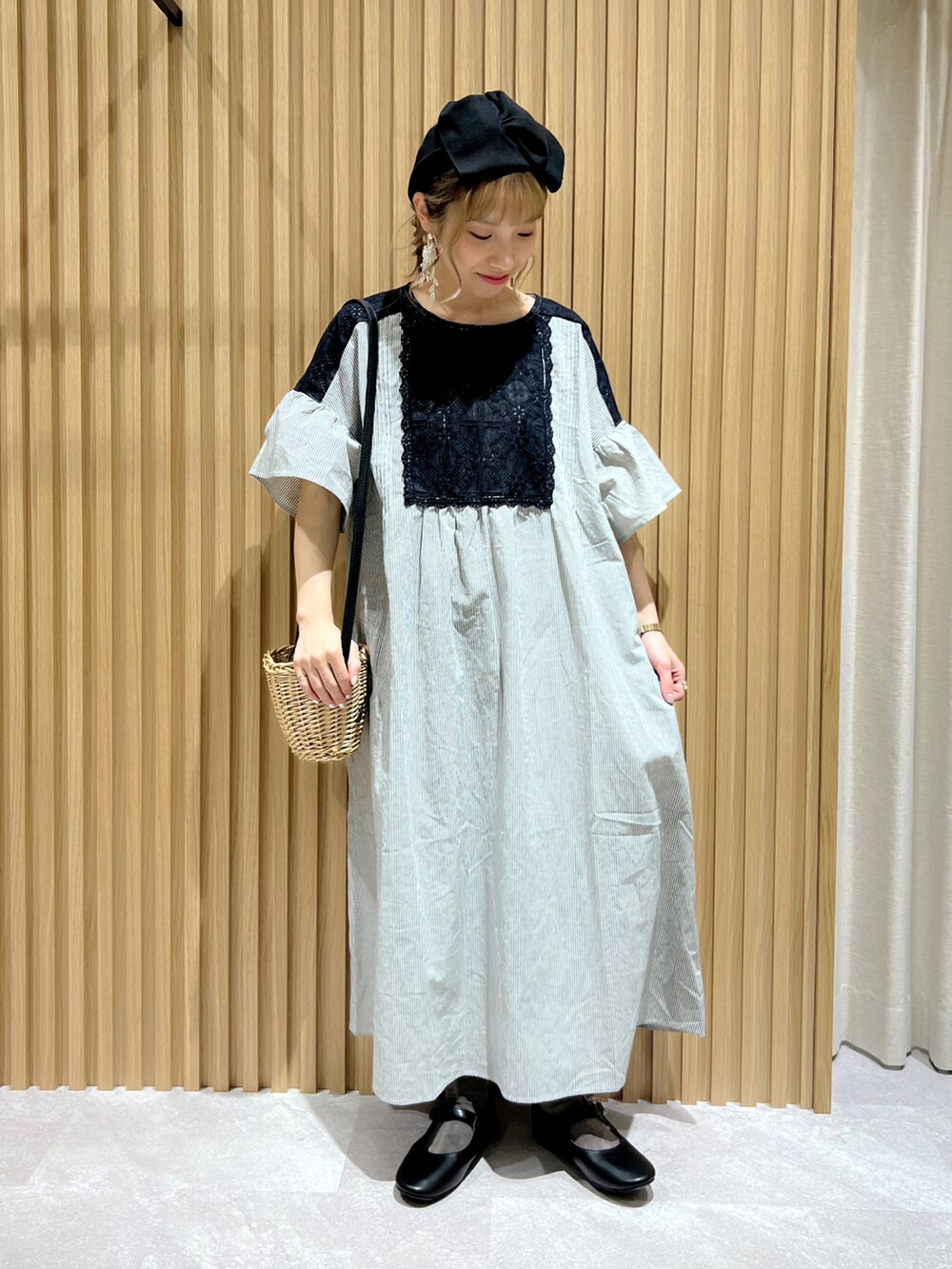 ブラック系のハンドバッグ、ブラック系のワンピースを着用したレディースの春コーディネートの2枚目の写真