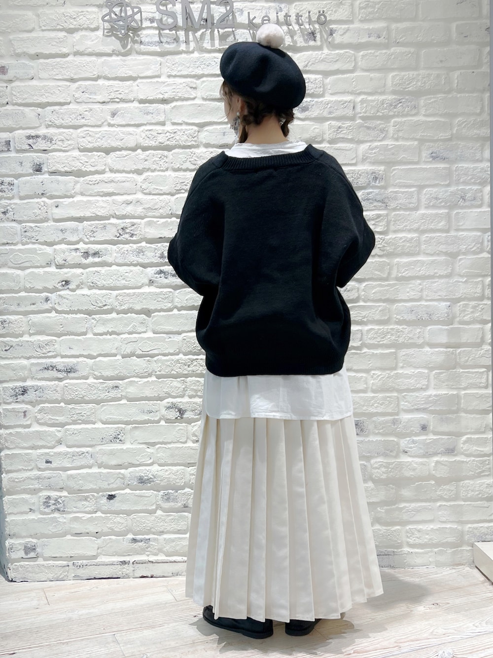 ホワイト系のスカート、ブラック系のカーディガン/ボレロ、ホワイト系のチュニックを着用したレディースの冬コーディネートの2枚目の写真