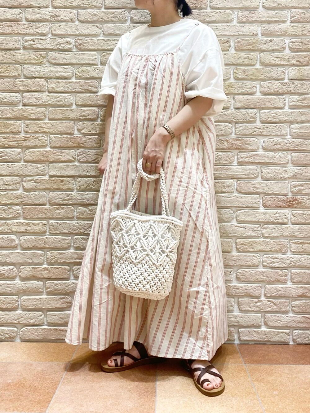 ブラウン系のシューズ、レッド系のワンピース、ホワイト系のTシャツ/カットソーを着用したレディースの春コーディネートの3枚目の写真