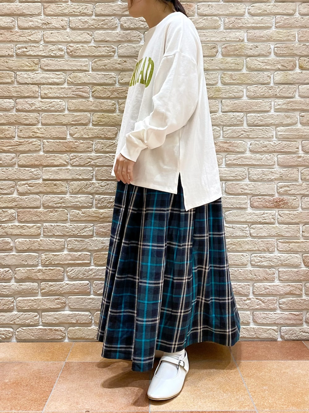 イエロー系のブルゾン、ホワイト系のTシャツ/カットソー、ブルー系のスカートを着用したレディースの春コーディネートの5枚目の写真