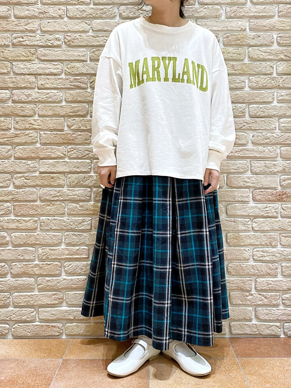 イエロー系のブルゾン、ホワイト系のTシャツ/カットソー、ブルー系のスカートを着用したレディースの春コーディネートの4枚目の写真