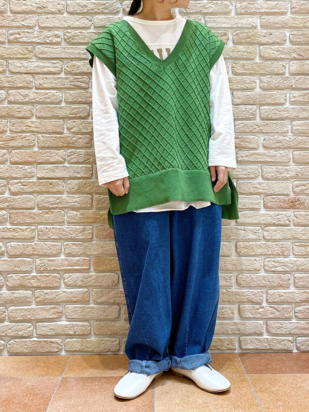 ホワイト系のTシャツ/カットソー、グリーン系のベスト、ベージュ系のブルゾンを着用したレディースの春コーディネートの4枚目の写真