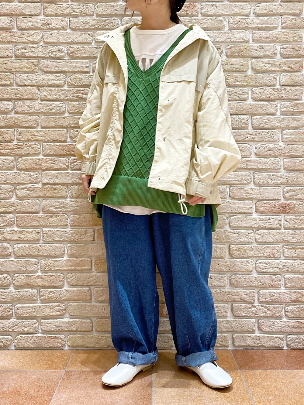 ホワイト系のTシャツ/カットソー、グリーン系のベスト、ベージュ系のブルゾンを着用したレディースの春コーディネートの2枚目の写真