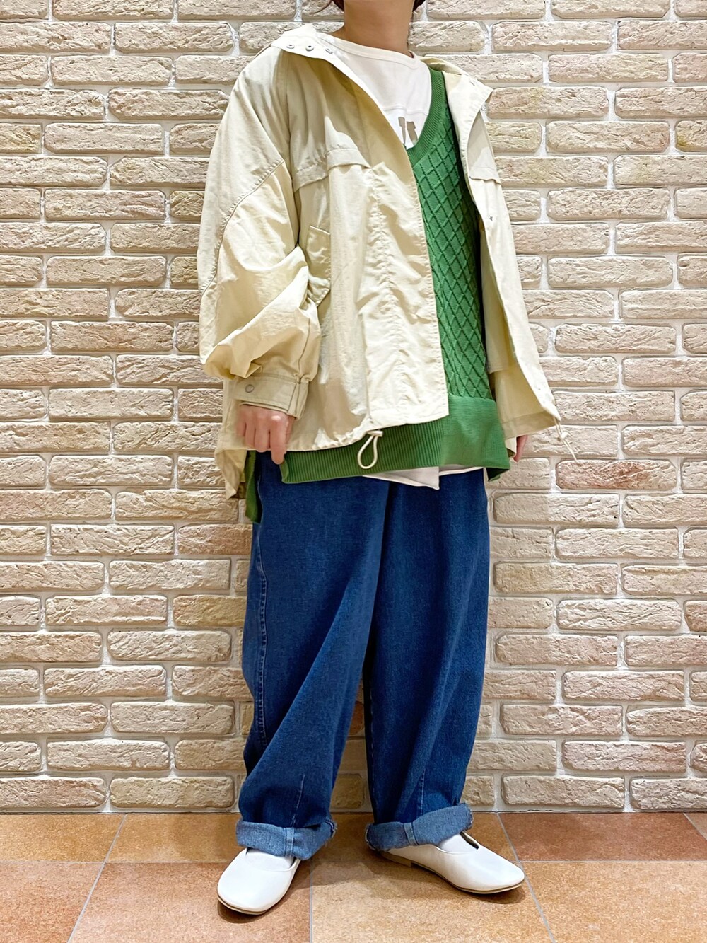 ホワイト系のTシャツ/カットソー、グリーン系のベスト、ベージュ系のブルゾンを着用したレディースの春コーディネートの3枚目の写真