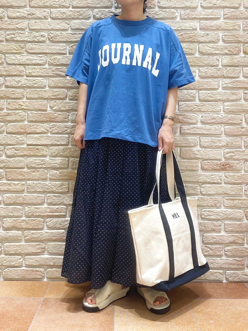 ブルー系のTシャツ/カットソー、ブラック系のスカート、ホワイト系のサンダルを着用したレディースの春コーディネートの3枚目の写真