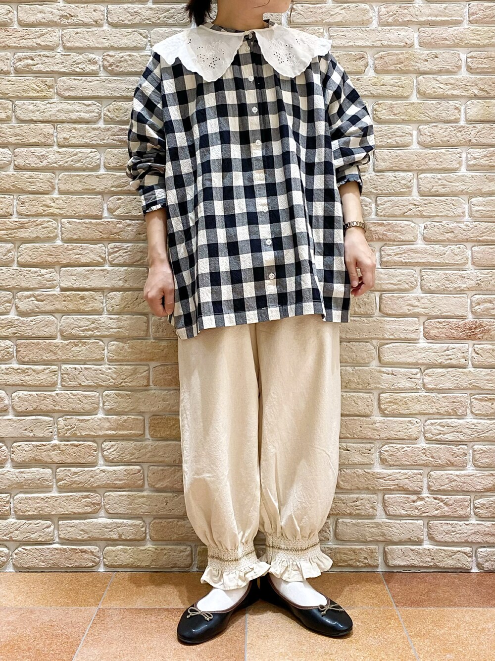 ブラック系のシャツ/ブラウス、ホワイト系のその他パンツ、ブラック系のドレスシューズを着用したレディースの春コーディネートの2枚目の写真