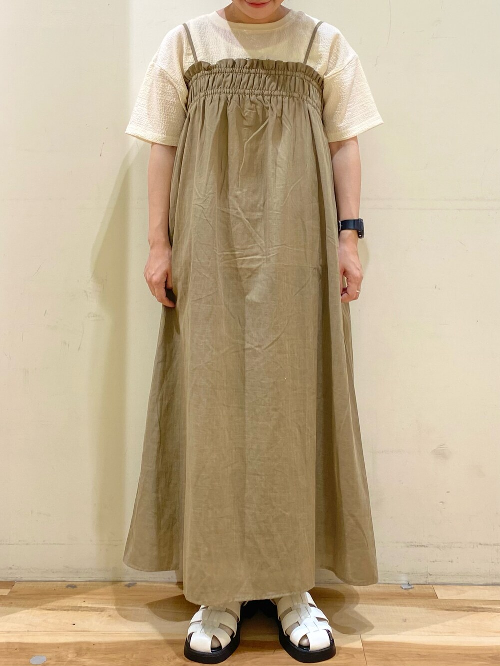 グリーン系のワンピース、ホワイト系のTシャツ/カットソー、ホワイト系のドレスシューズを着用したレディースの春コーディネートの2枚目の写真