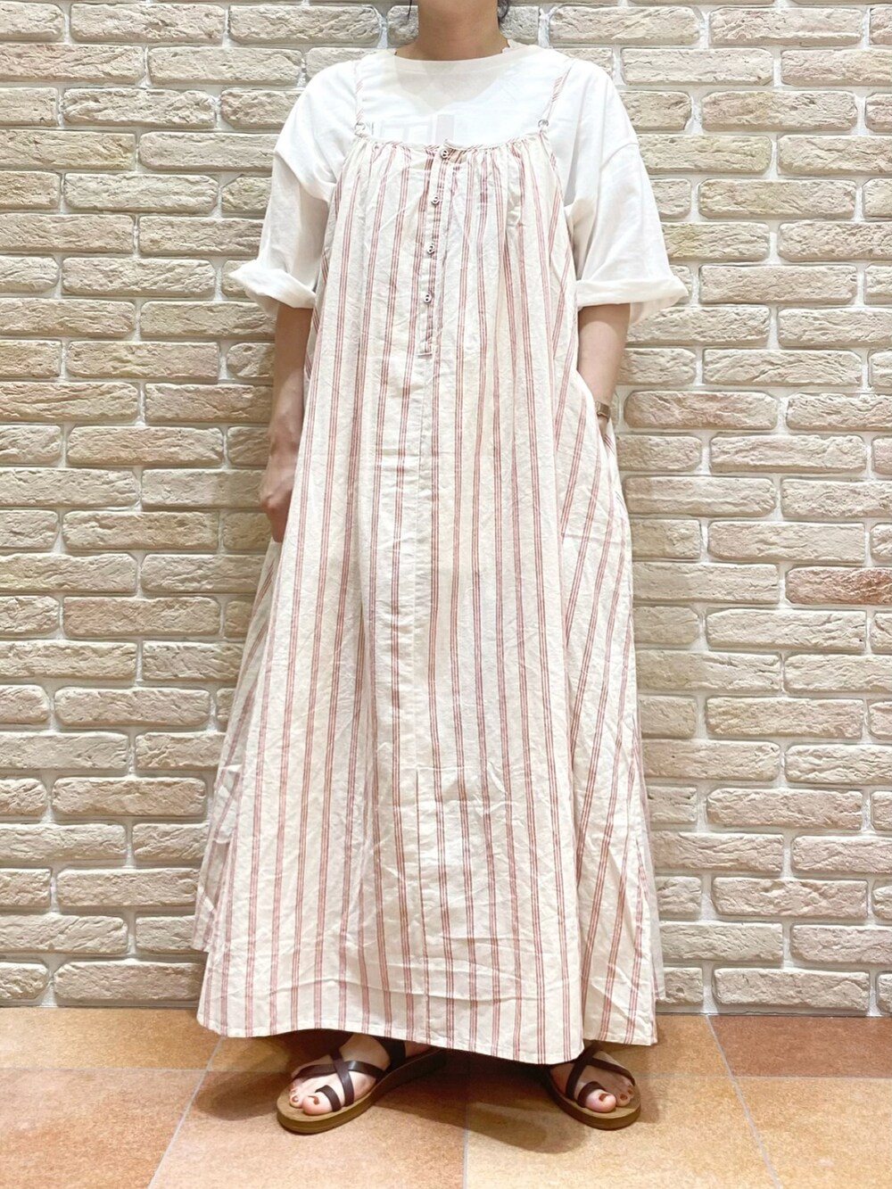ブラウン系のシューズ、レッド系のワンピース、ホワイト系のTシャツ/カットソーを着用したレディースの春コーディネートの2枚目の写真