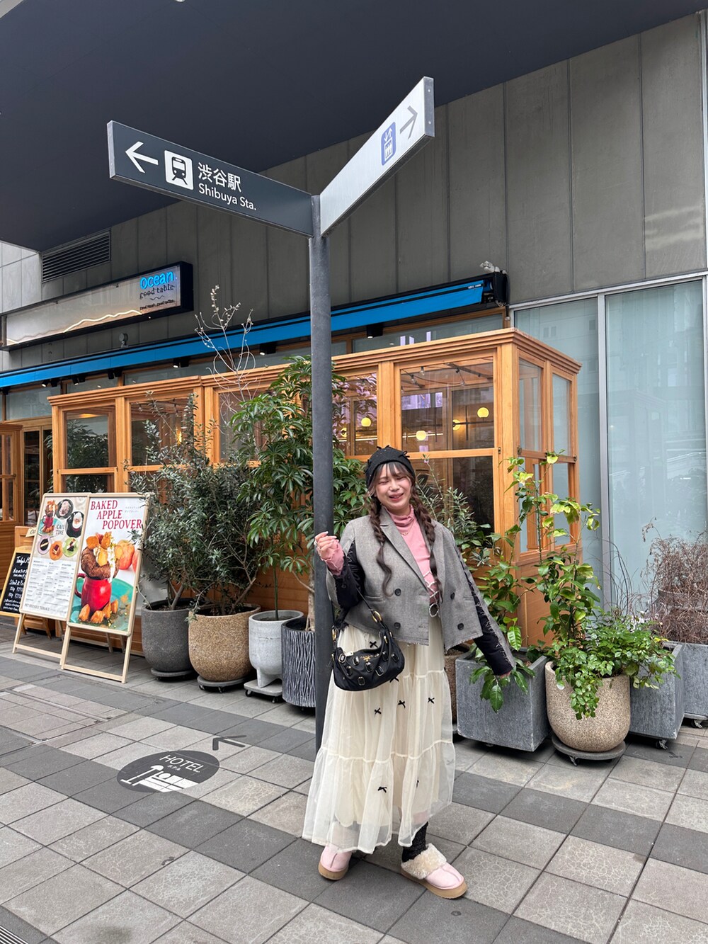 ブラウン系のテーラードジャケット、ピンク系のスリッポン、ホワイト系のベストを着用したレディースの秋コーディネートの2枚目の写真