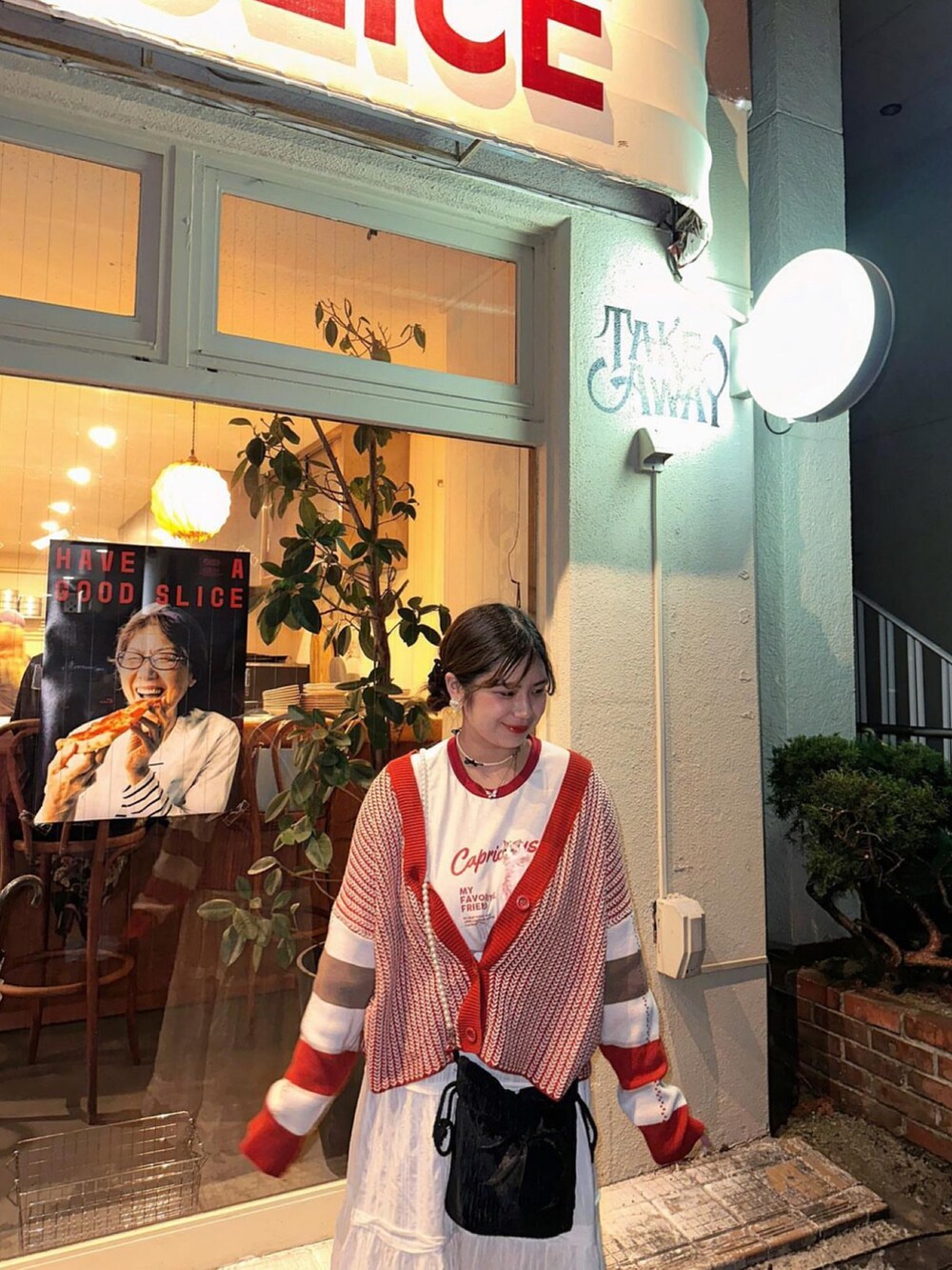 レッド系のカーディガン/ボレロ、ホワイト系のスカート、レッド系のTシャツ/カットソーを着用したレディースの秋コーディネートの2枚目の写真