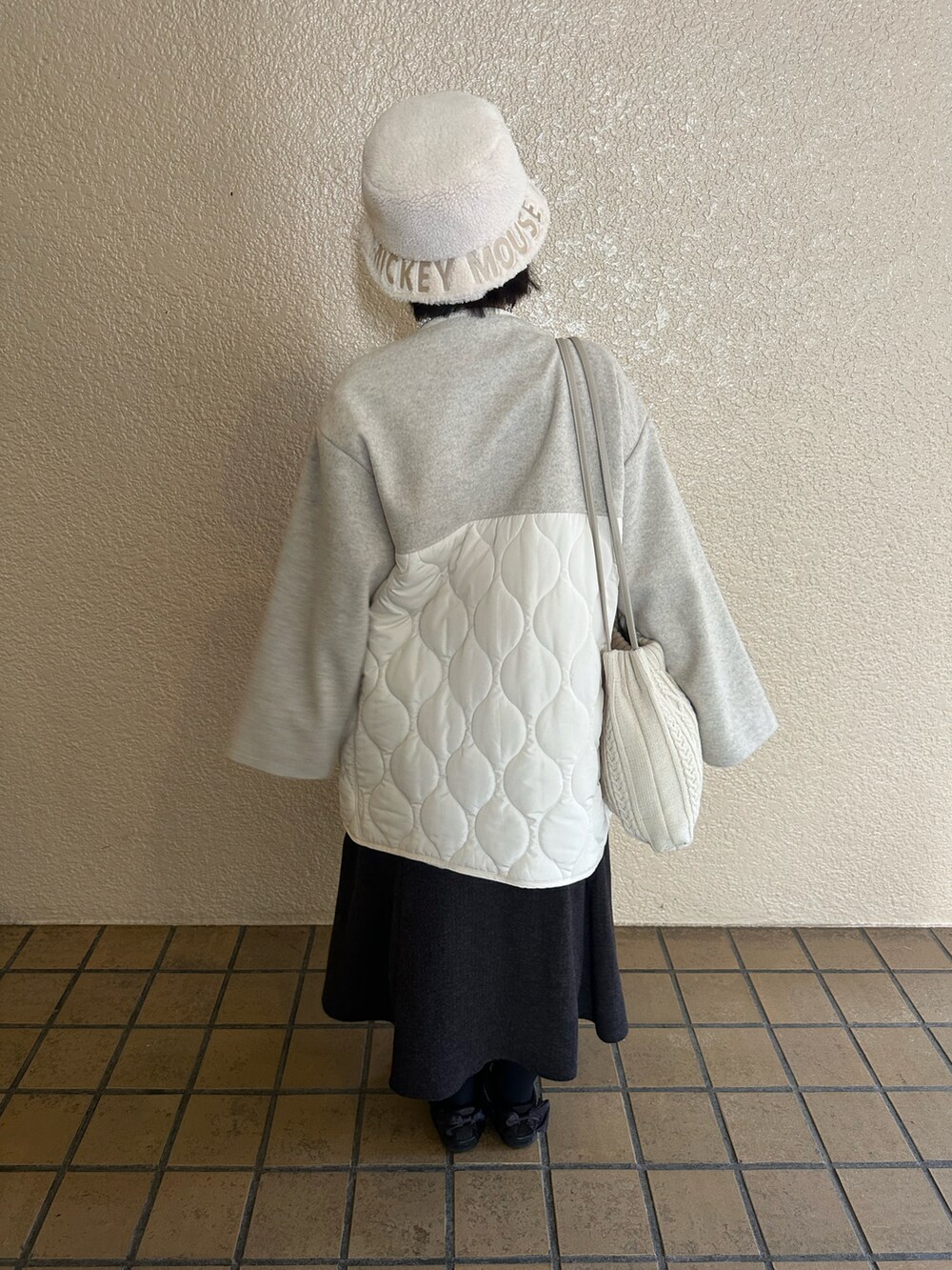ホワイト系のニット/セーター、グレー系のスカート、ホワイト系のジャケット/アウターを着用したレディースの秋コーディネートの2枚目の写真