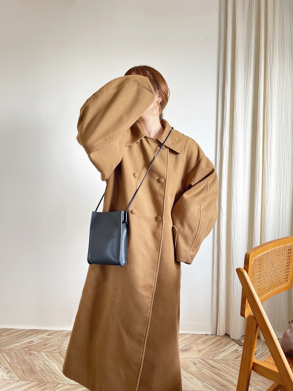 ブラウン系のステンカラーコートを着用したレディースの冬コーディネートの3枚目の写真