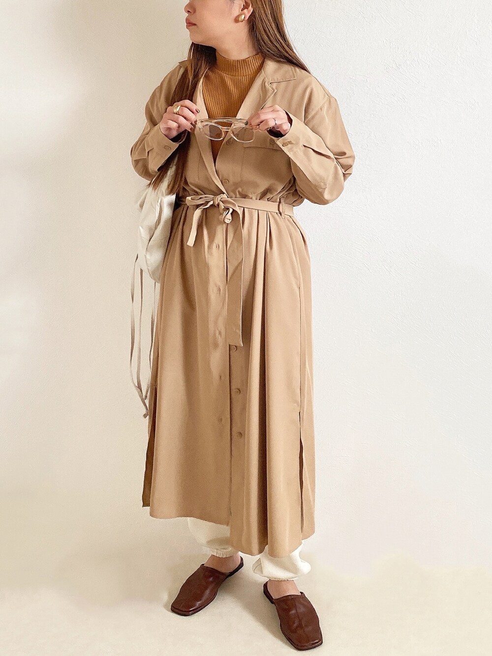 イエロー系のトップス、ベージュ系のワンピース/ドレス、ホワイト系のスウェットパンツを着用したレディースの春コーディネートの3枚目の写真