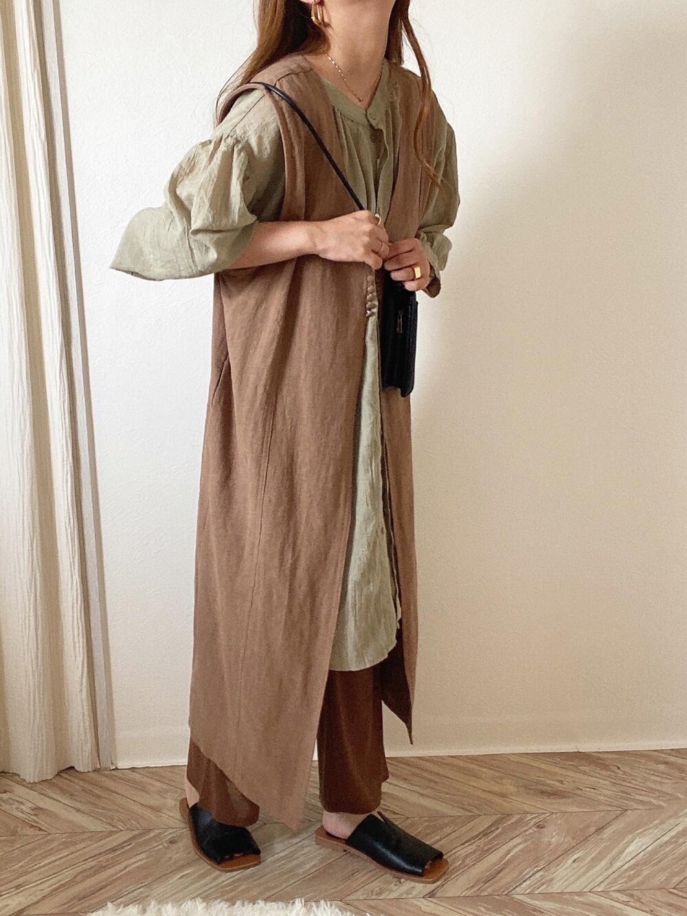 グリーン系のシャツ/ブラウス、ブラウン系のベスト、ブラック系のショルダーバッグを着用したレディースの夏コーディネートの4枚目の写真